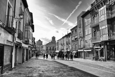 People walking on street amidst buildings in city