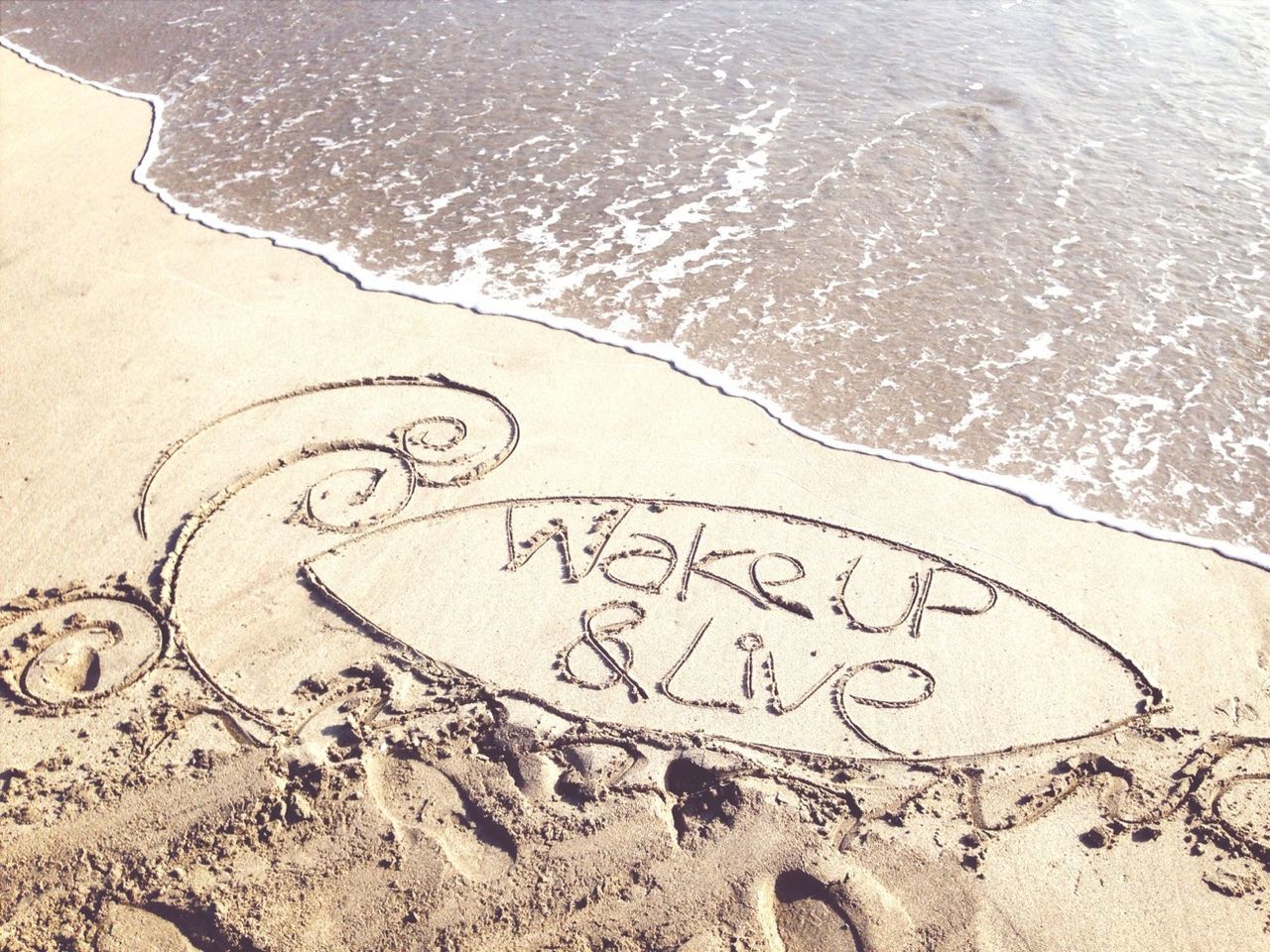 water, beach, sand, high angle view, shore, text, western script, communication, sea, footprint, rippled, wave, tranquility, nature, day, outdoors, surf, no people, pattern, sunlight