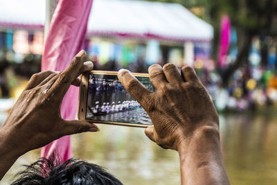 Close-up of person hands photographing with mobile phone by river