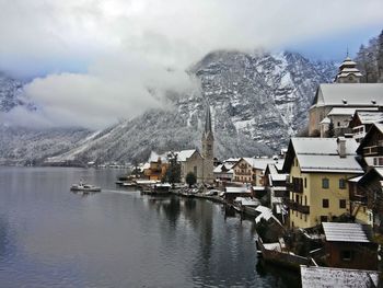 Panoramic view of buildings and mountains against sky during winter