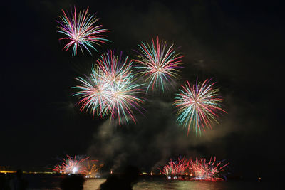 Low angle view of firework display at night