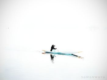 Man on boat in sea against sky