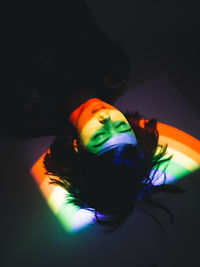 High angle view of rainbow light falling on woman sleeping at home