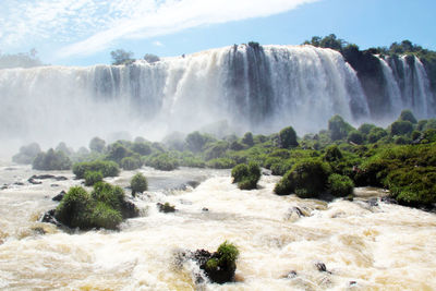 Scenic view of waterfall against sky