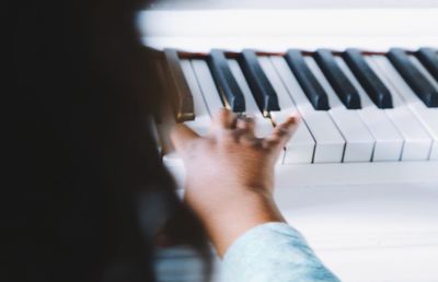 Cropped hand of child playing piano