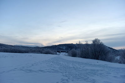 Snow covered landscape against sky