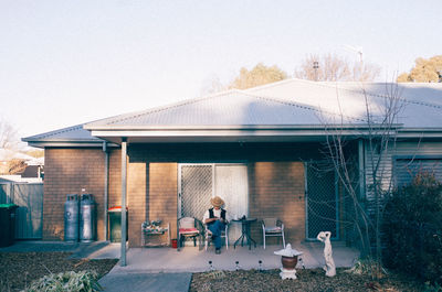 People sitting on table by building against sky