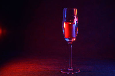 Glass of wineglass on table against black background