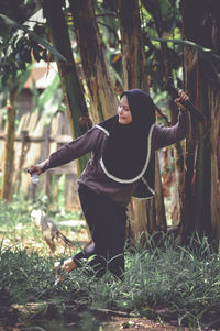 Rear view of woman standing in forest