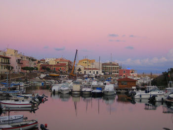 Boats moored at harbor against sky