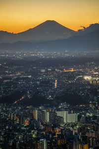 Aerial view of illuminated cityscape against sky at night