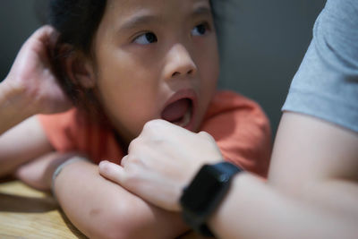 Close-up of cute girl with open mouth by father at home