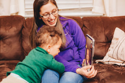 Smiling mother and son talking on video call at home