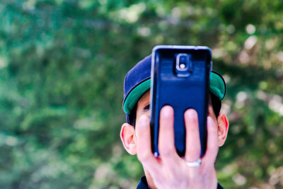 Close-up of hand holding smart phone outdoors