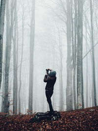 Full length of woman standing in forest during winter