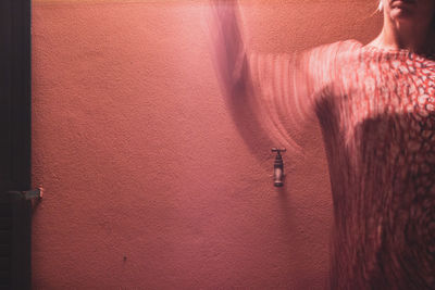 Close-up of woman hand on red door