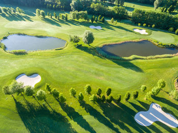 High angle view of golf course by lake