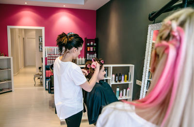 Woman holding umbrella while sitting in store