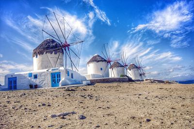 Traditional windmill on beach against sky