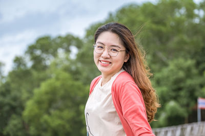 Portrait of smiling young woman standing outdoors