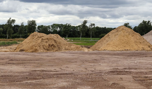 Hay bales on field against sky