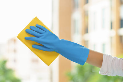 Midsection of person holding yellow umbrella