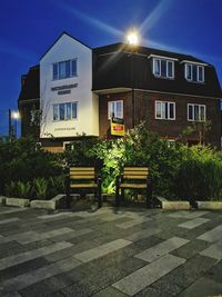 Houses by street in city against sky at night