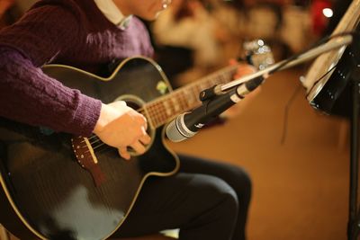 Musical performer tuning guitar on stage