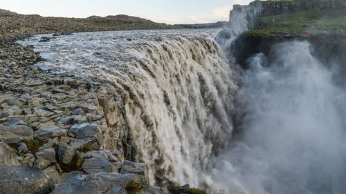 Scenic view of waterfall against sky