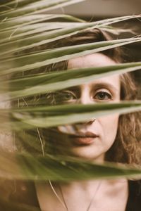 Close-up portrait of young woman seen through plants