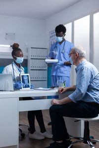 Patient discussing with doctor in clinic during pandemic