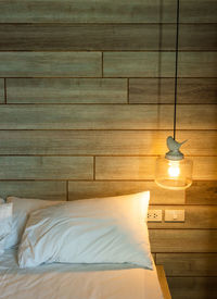 High angle view of illuminated electric lamp on bed against building