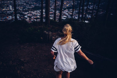 Rear view of woman running in forest