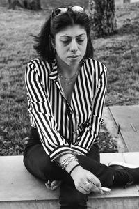 Portrait of young woman sitting on wood