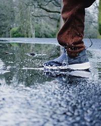 Low section of person standing in water