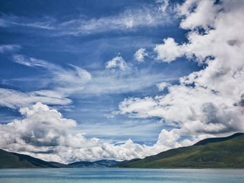 Scenic view of sea and mountains against sky