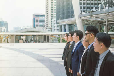 Businesspeople standing by buildings in city