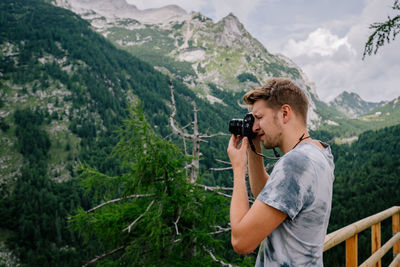 Side view of man photographing mountains