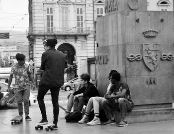 People sitting on building in city