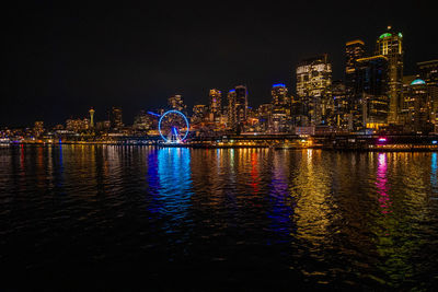 Seattle coastline illuminated at night and reflecting in elliott bay
