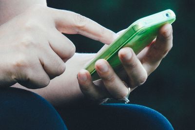 Close-up of woman holding smart phone