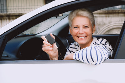 Young woman using mobile phone while sitting in car