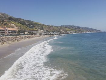 Scenic view of beach against clear blue sky