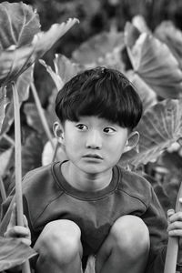 Portrait of cute boy sitting outdoors