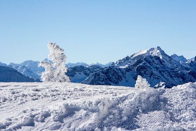 Scenic view of snow covered mountain against blue sky