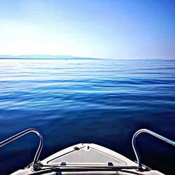 Boat sailing in sea against blue sky
