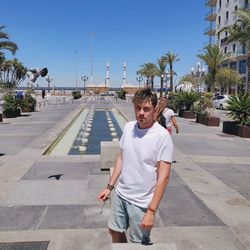 Portrait of man standing in city against clear sky