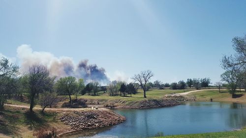 Remote smoke at the horizon near pond