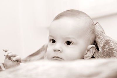 Close-up of cute baby boy on bed at home