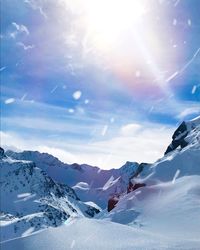 Scenic view of snowcapped mountains against sky on sunny day